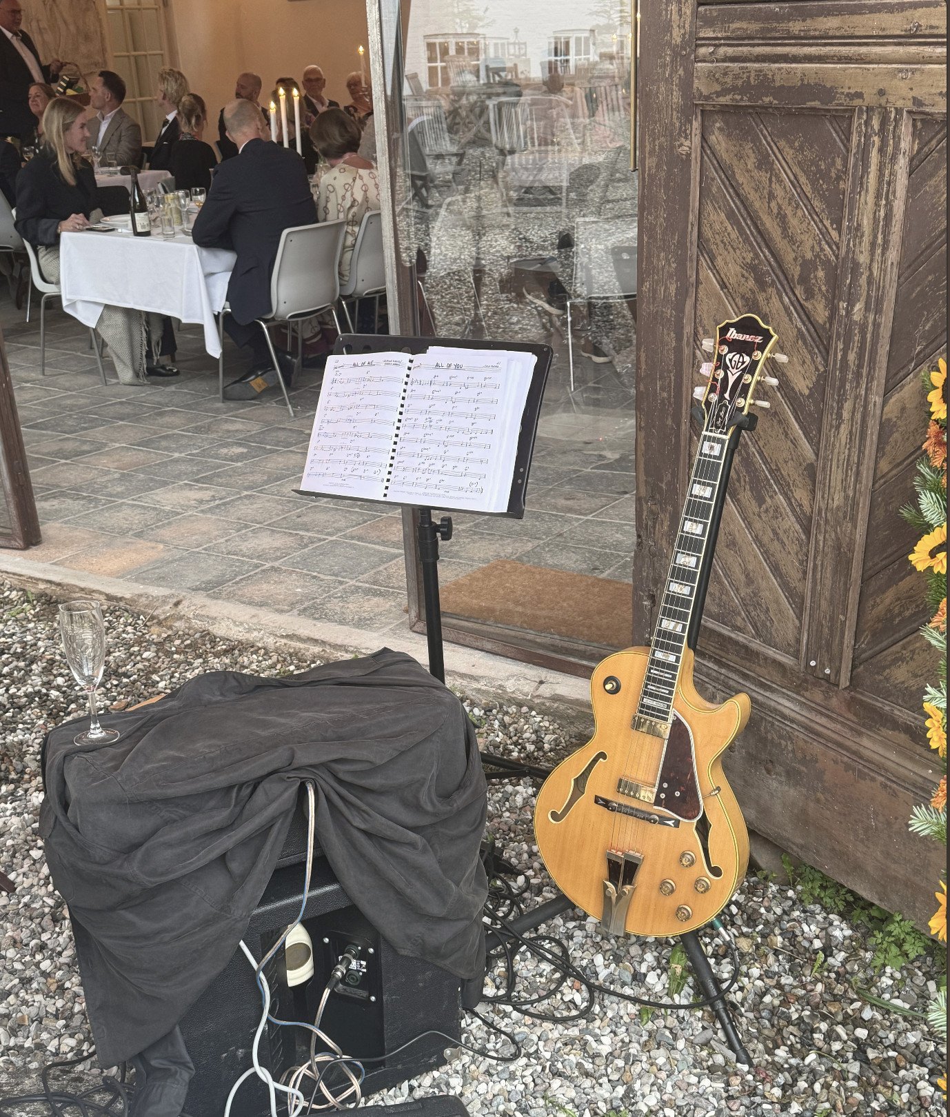 Guitar og nodestativ ved døren til festmiddagen